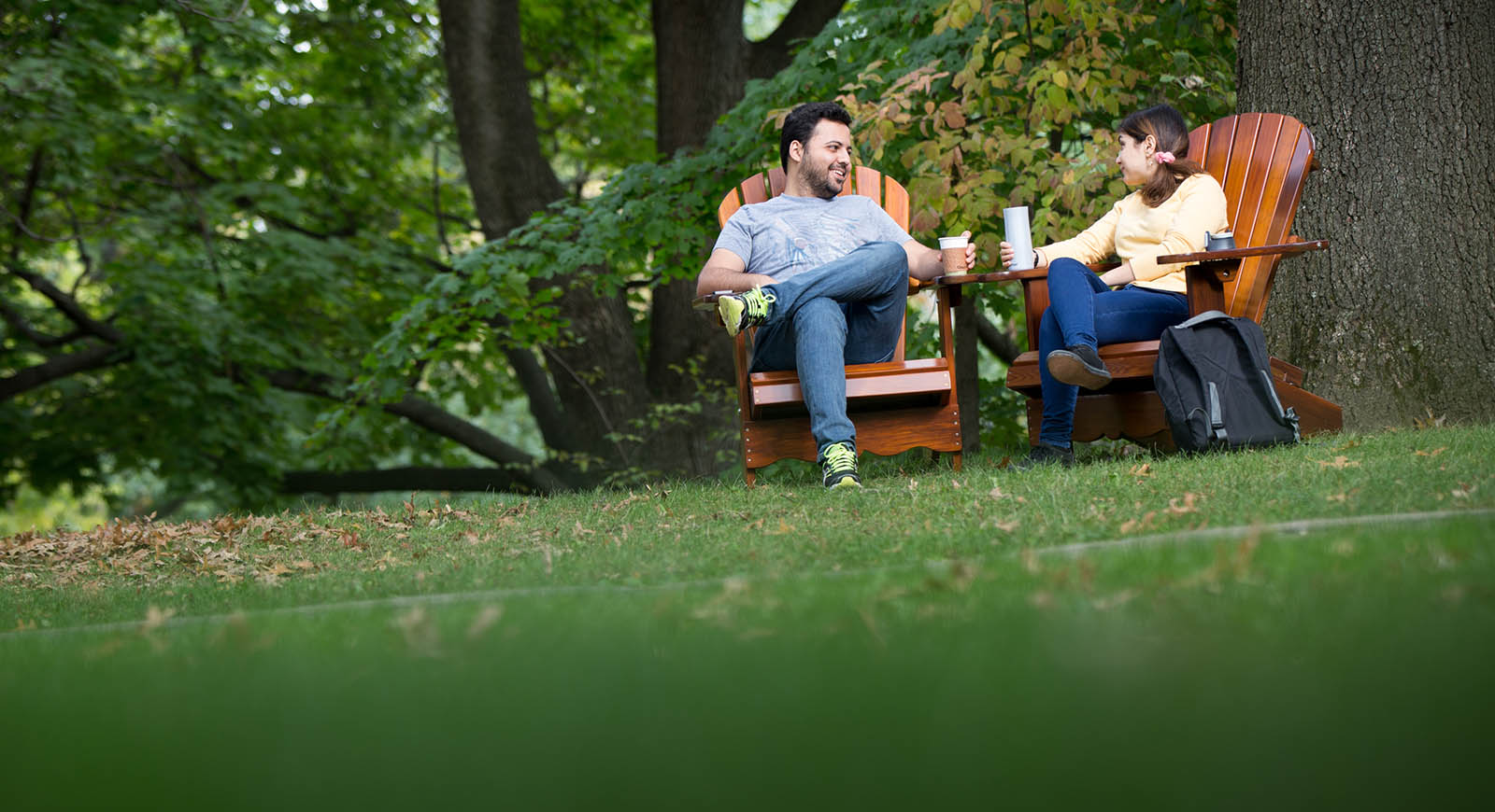 Photo of two students seated on Adirondack chairs outside on Shadyside Campus