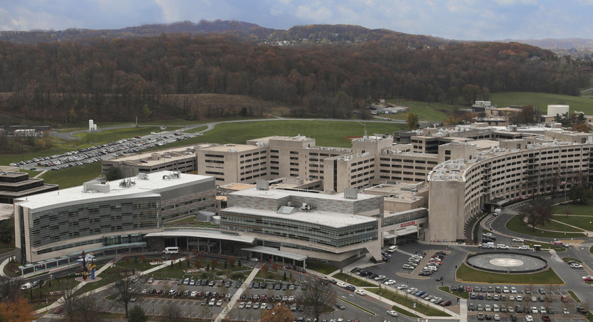 Aerial photo of a complex of buildings (Penn State Health Milton S. Hershey Medical Center) with mountains in the background.