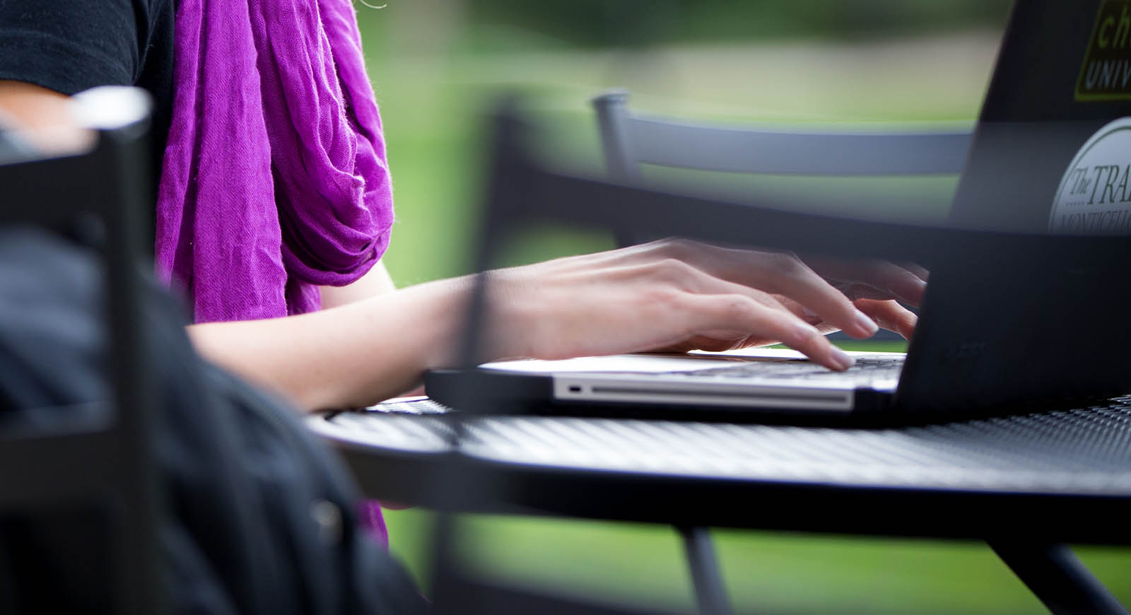 Close-up of a person typing on a laptop outside on a table in Shadyside Campus