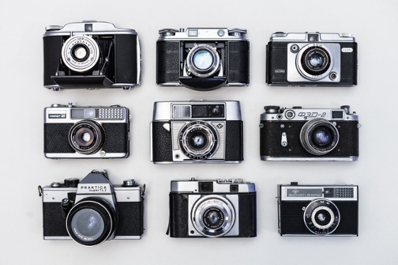 Photo of nine black film cameras are arranged in a square.