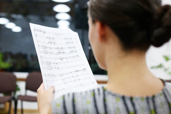 Photo of a woman with dark hair reading sheet music