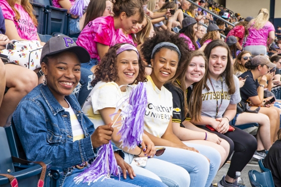 Photo of Chatham University students at a Pittsburgh Pirates baseball game, posing for the camera while seated
