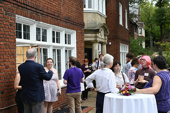 Photo of a middle-aged woman speaking to a young college student at an event