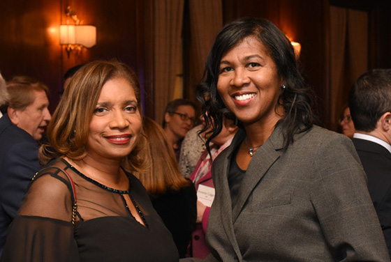 Photo of two women posing for the camera at a networking event