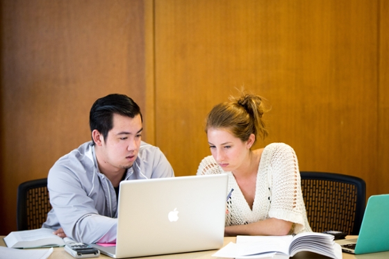 Photo of two Chatham University students looking at a laptop together.