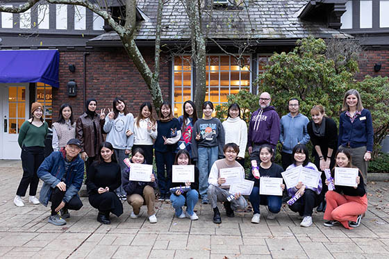 Photo of a group of international students posing together with certificates of completing the English Language Program