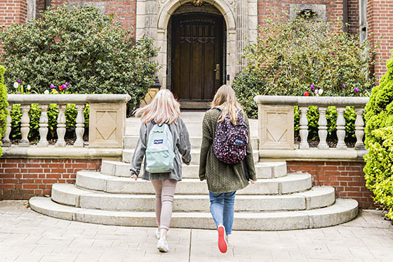 Two students walk into a historic mansion on Shadyside Campus