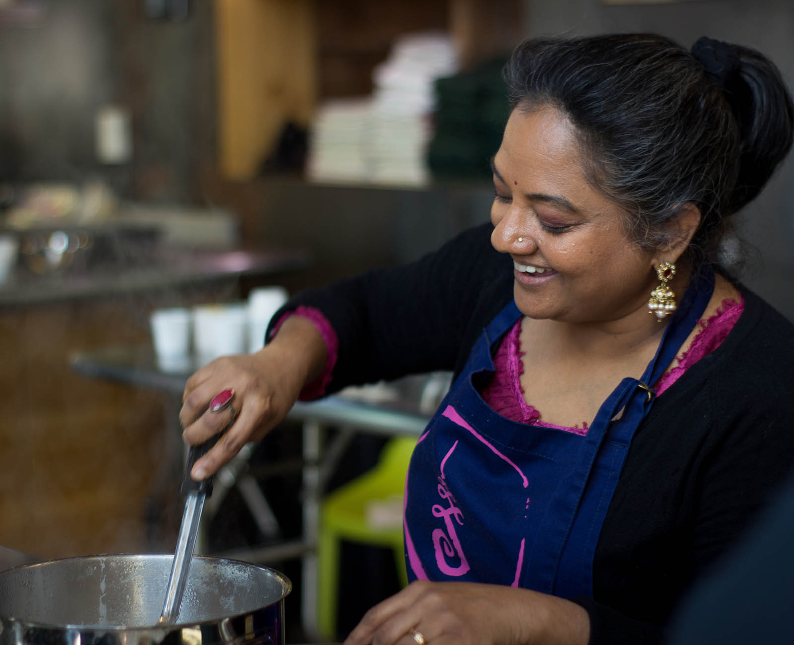 Photo of a smiling woman in an apron cooking