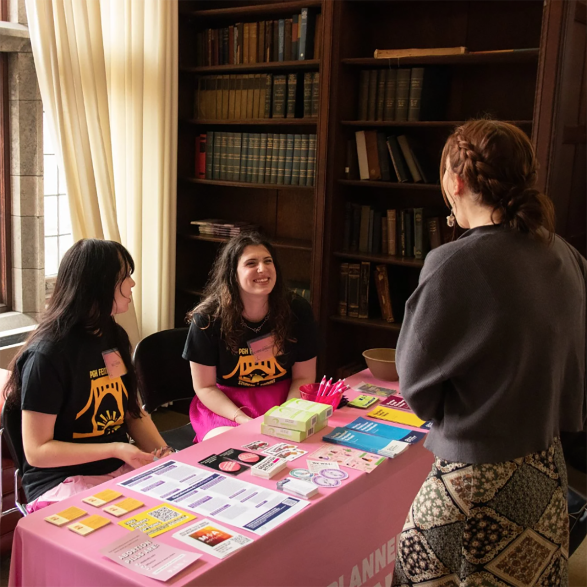 Students tabling at the 2025 Pittsburgh Feminist Student Summit speak to an attendee. (Lucas Barnes)