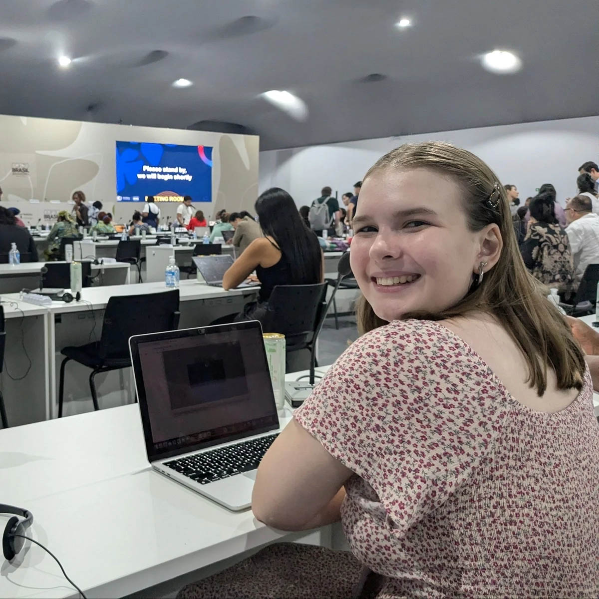 Marley McFarland sits at a desk at a UN COP 30 event in Belém, Brazil