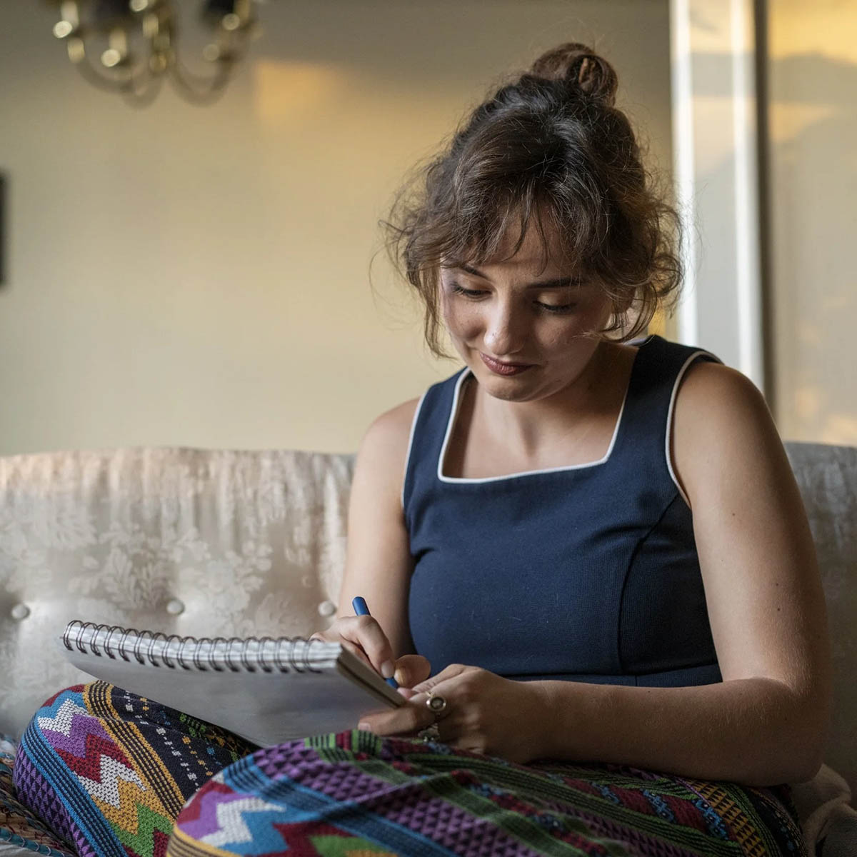 Natalie Callahan sketches in her notebook while her cat watches. (Annie O’Neill)