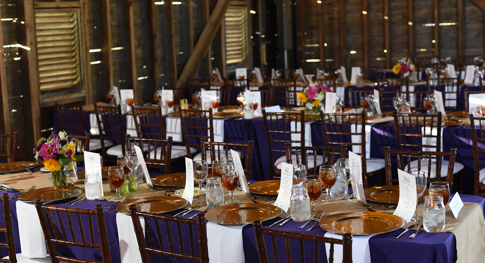 Photo of dining place settings in large barn on Eden Hall Campus