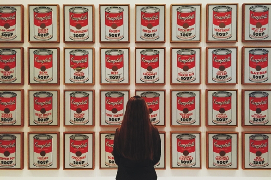 Photo of a woman standing in front of Andy Warhol soup can artwork at art museum in Pittsburgh. 