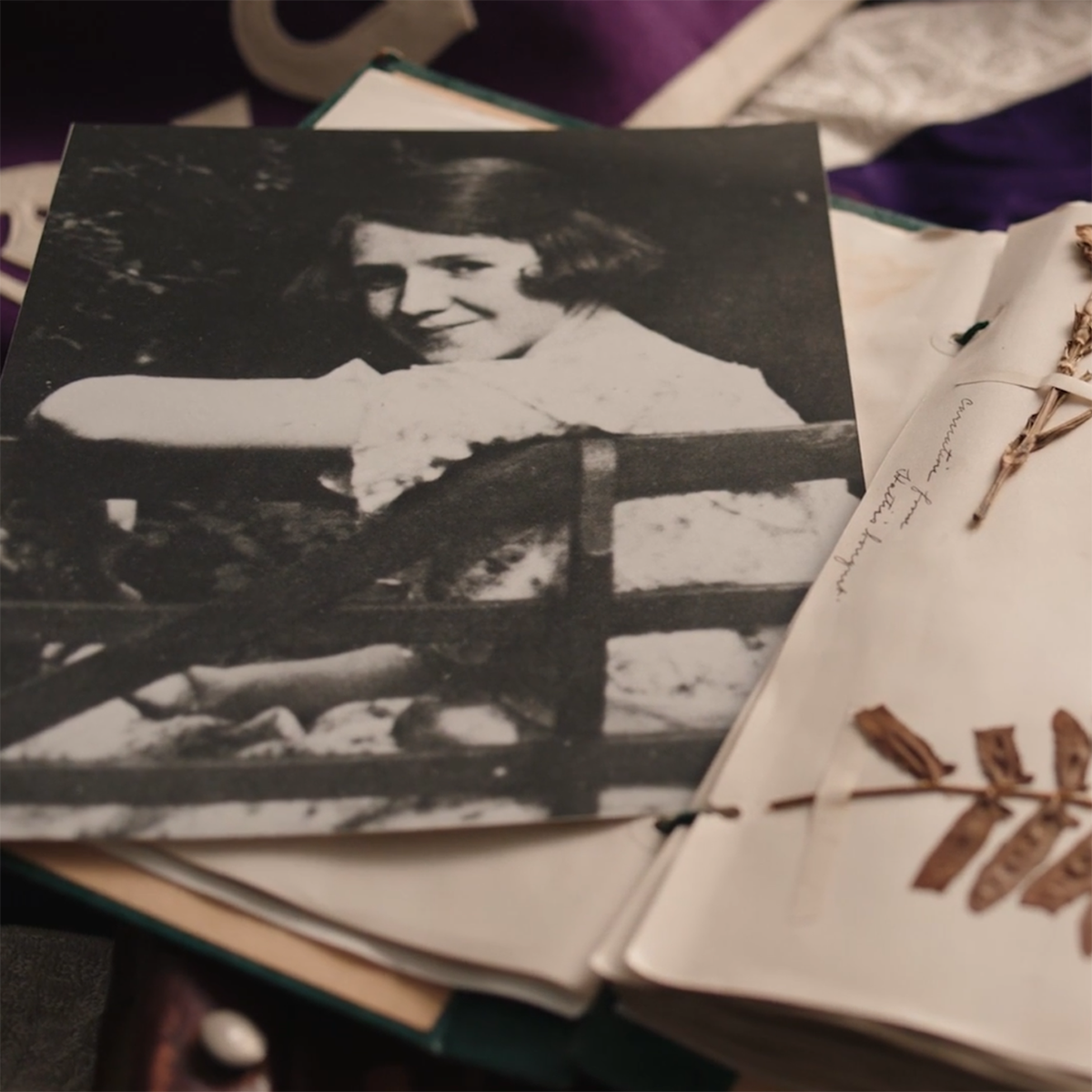 Close-up photo of a scrapbook with dried flowers and a black and white photo clipping of Rachel Carson