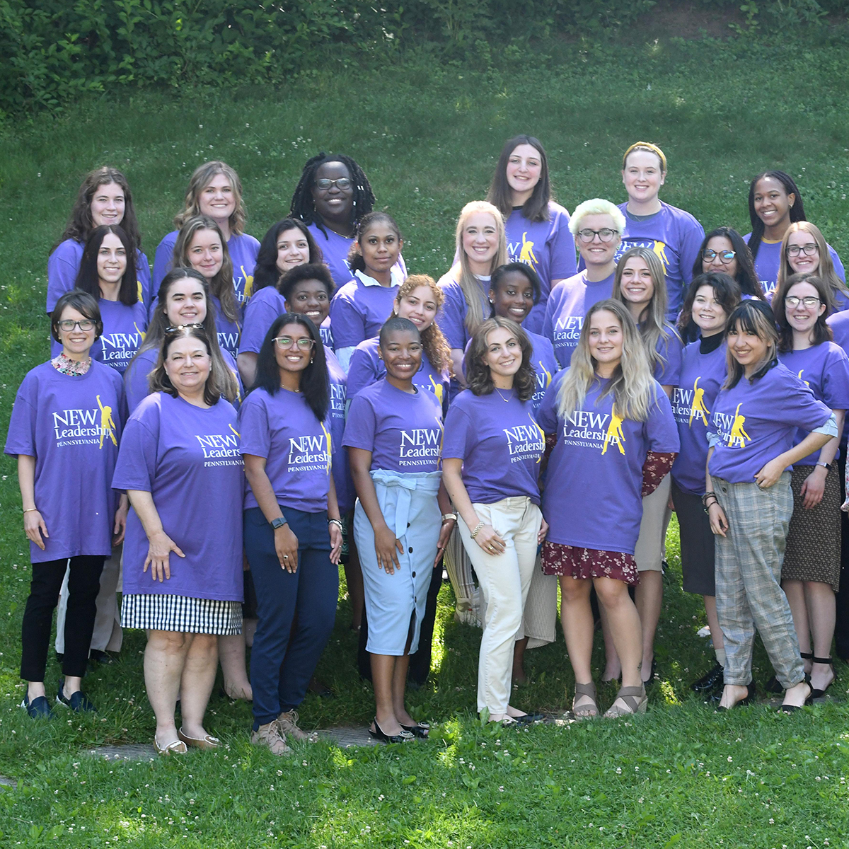 Photo of a group of women in purple NEW Leadership t-shirts posing for a photo outside
