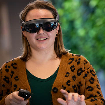 Photo of a Chatham University Immersive Media student wearing virtual reality goggles.
