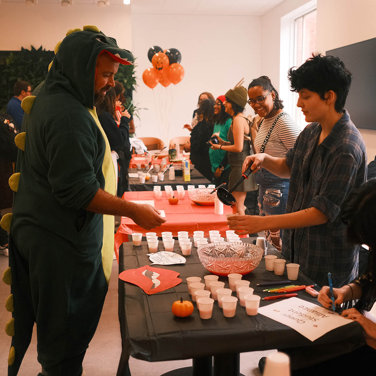 Photo of students in Halloween costumes serving and receiving mocktails
